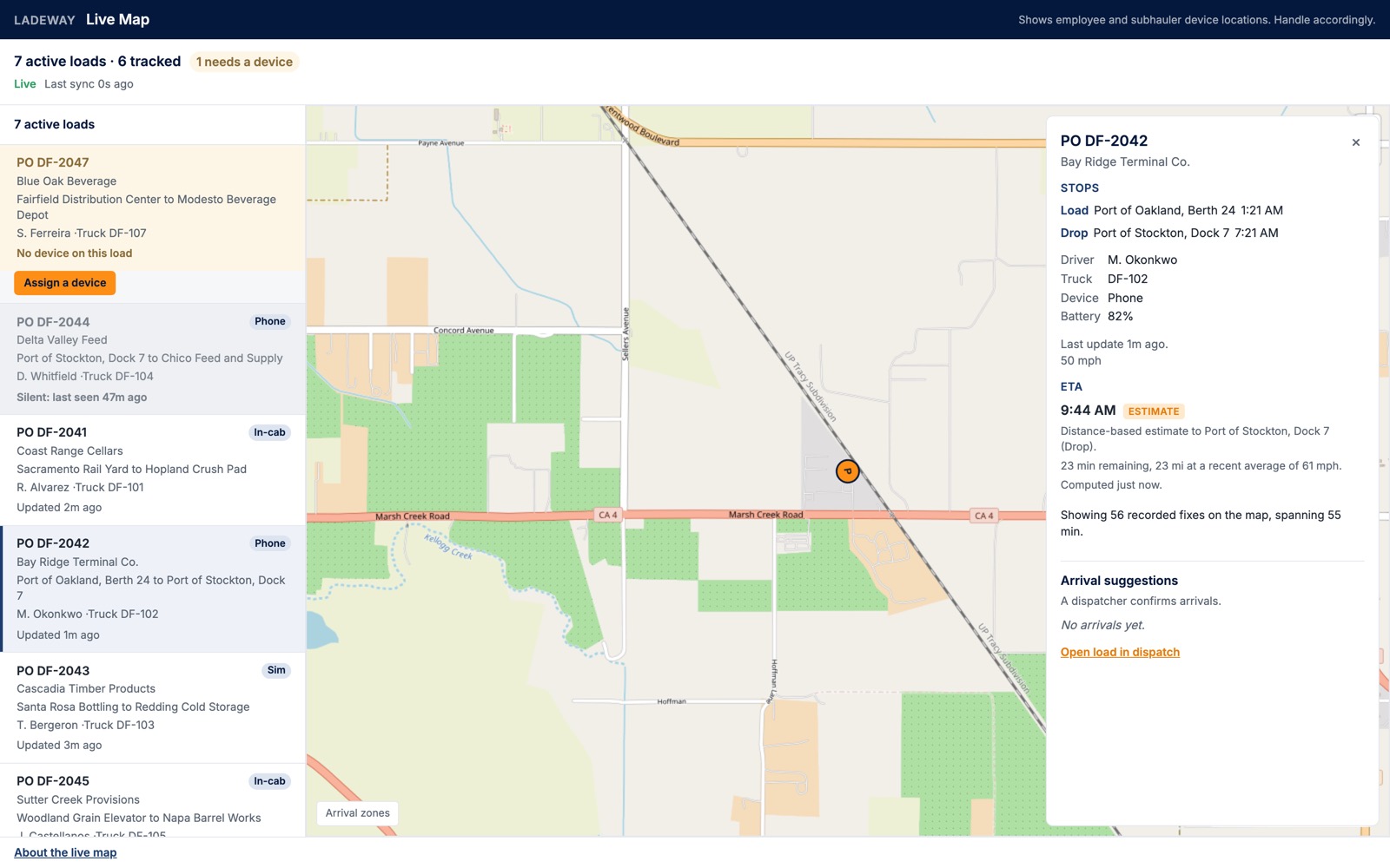 A load card open beside the live map. It lists both stops with their times, the driver, the truck, the device, a battery at 82 percent and a current speed of 50 miles per hour, then an estimated arrival time under a chip reading Estimate, with one line naming the stop it is measured to.